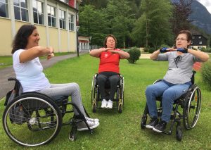 Drei Frauen beim Rollstuhl-Aerobic im Freien